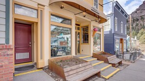 A building with a red door, large windows, and a bench outside. - Walk to Hot Springs: Updated Retreat in Dtwn Ouray (Ouray)