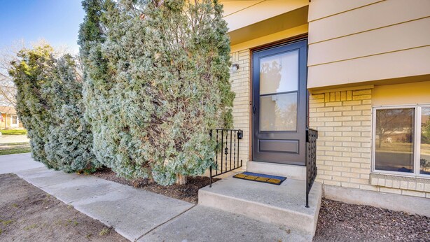 A building entrance with a concrete pathway, a metal gate, and a door with a window. - 2 Mi to Citadel Mall: Home w/ Furnished Patio! (Colorado Springs)