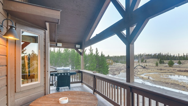 A wooden deck with a table and chairs, a grill, and a view of a natural landscape. - Deck + Mountain Views: Fairplay Family Escape! (Fairplay)