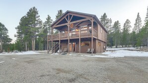 A wooden lodge with a balcony, surrounded by trees and a gravel driveway. - Deck + Mountain Views: Fairplay Family Escape! (Fairplay)