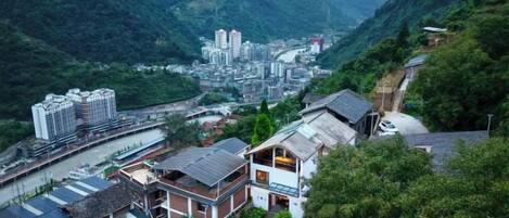 Un pueblo montañoso con edificios, un río y un puente.