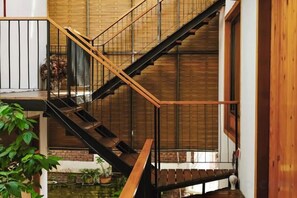 A multi-level interior with a staircase, wooden railings, and a small water feature. - Baoxingtian Sister Inn (Baoxing)