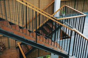 Una escalera de madera de varios niveles con barandillas de metal.