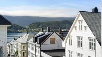A row of white buildings with a view of a lake and mountains in the background.