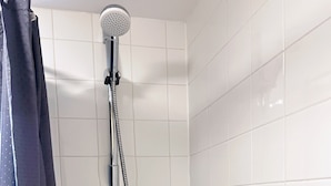 A shower with a handheld showerhead and a flexible hose, white tiled walls, and a dark curtain. - Lovely apartment with WiFi in charming Stretford (Stretford)