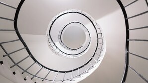 Eine Wendeltreppe mit einer zentralen Säule und Geländern auf beiden Seiten.