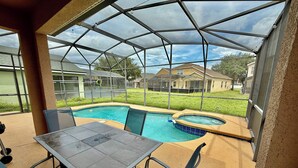 A covered outdoor area with a pool and hot tub, surrounded by a glass enclosure. - Disconnect to Reconnect! (Davenport)