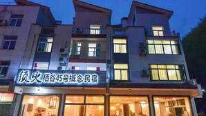 A multi-story building with illuminated signage and large windows. - Moment Inn (Huangshan City)