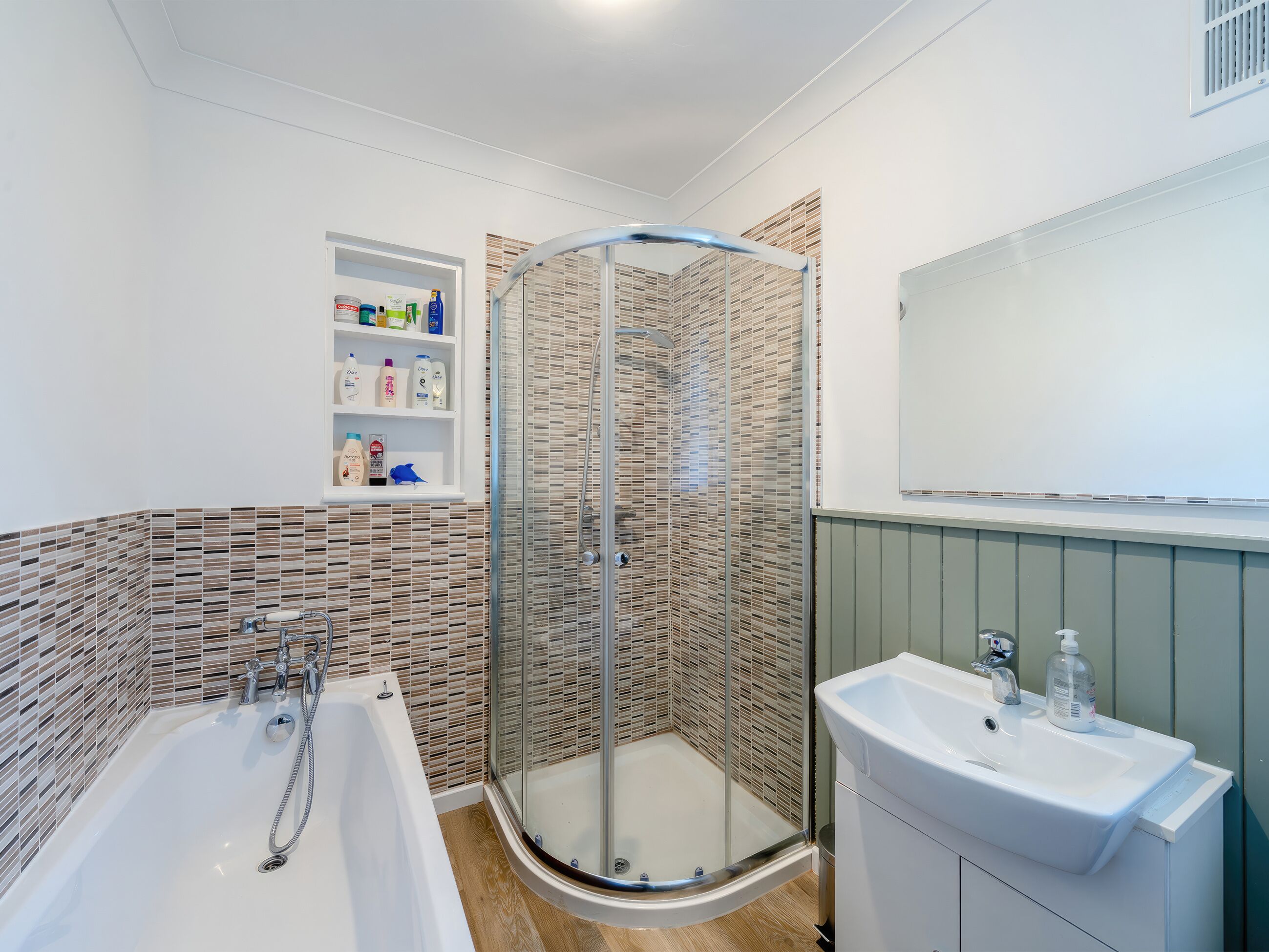 A modern bathroom with a glass-enclosed shower, a freestanding bathtub, and a vanity with a sink.