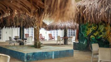 Habitación triple Deluxe | Área de sala de estar | Chimenea y libros