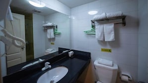 A hotel bathroom with a black sink, white toilet, and a mirror. There are towels hanging on a rack and a hairdryer on the wall. - Yunjiang Business Hotel (Shanghai Nanle Road Branch) (Shanghai)