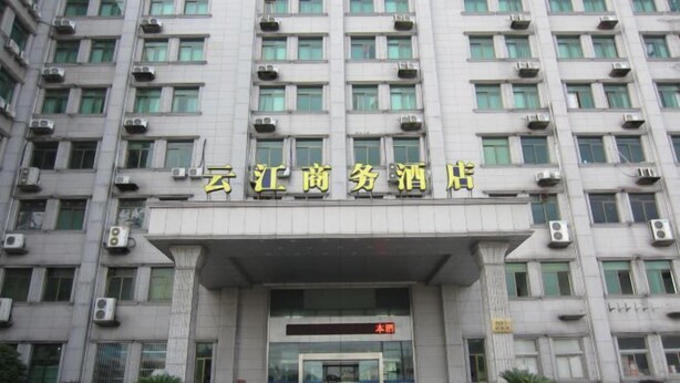 A hotel entrance with a large sign in yellow characters, air conditioning units, and a digital display above the entrance. - Yunjiang Business Hotel (Shanghai Nanle Road Branch) (Shanghai)