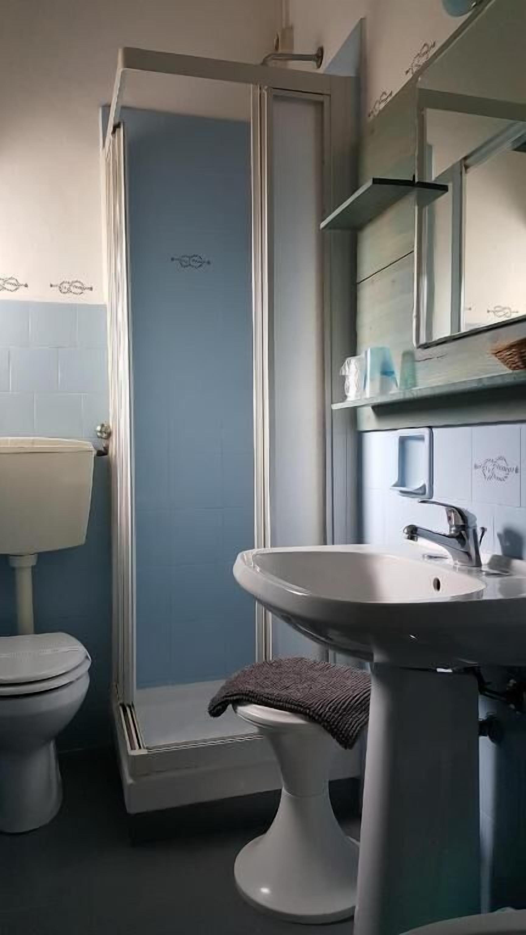 Ein Badezimmer mit Duschkabine, Toilette und Waschbecken.