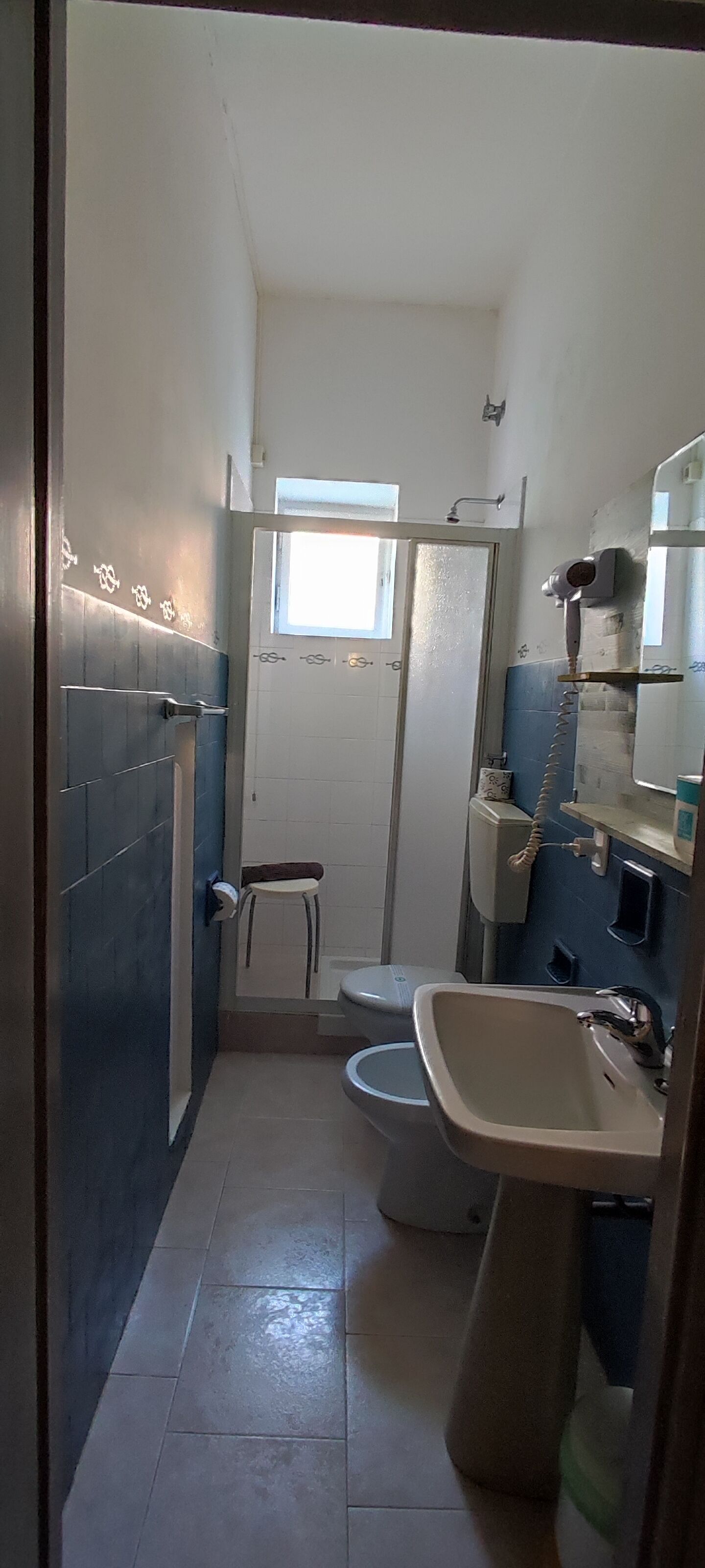A compact bathroom with a toilet, sink, and shower.