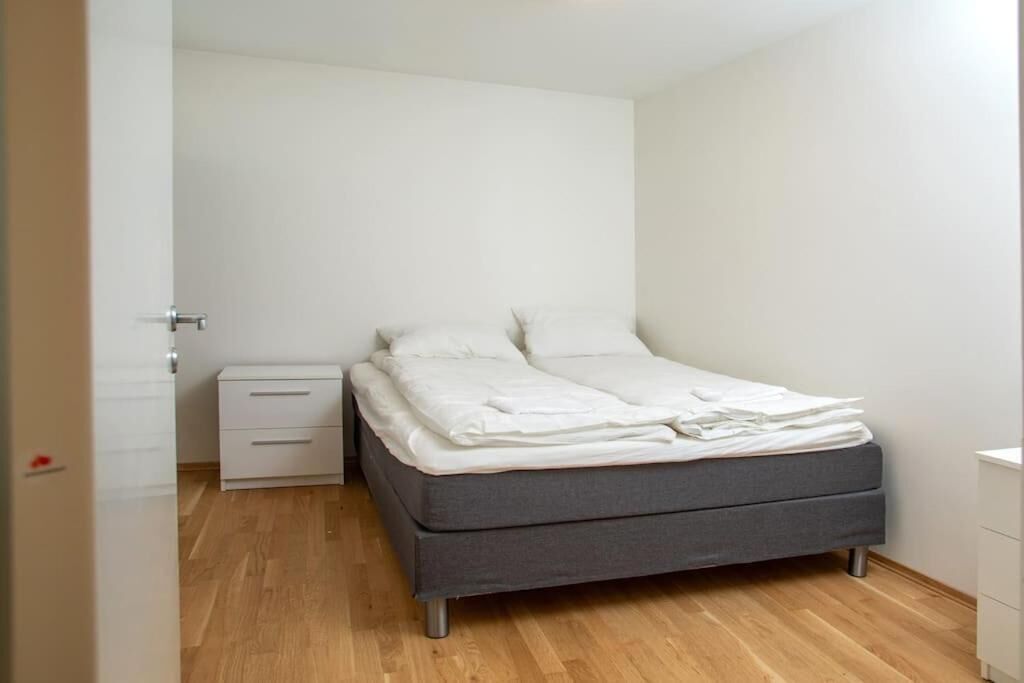 A bedroom with a bed, a nightstand, and a dresser.