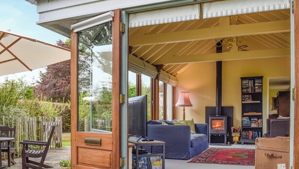 An open living area with a sofa, TV, fireplace, and bookshelf.