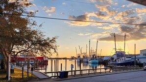 Un puerto deportivo con barcos amarrados, una cubierta de madera y un cielo despejado.