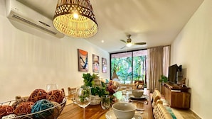 A dining area with a wooden table set for two, a woven basket, and a ceiling fan.