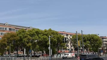 A street view with buildings, trees, and vehicles.