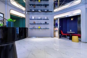 A modern interior with a central open space, shelves with items, and seating areas. - 100 Inn (Shanghai Hongqiao Airport National Exhibition and Convention Center) (Shanghai)