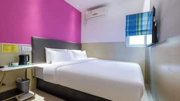 A hotel room with a bed, bedside table, and a window with a view.