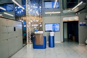 A reception area with a glass wall, a reception desk, and a digital information board. - 100 Inn (Shanghai Hongqiao Airport National Exhibition and Convention Center) (Shanghai)