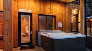 A wooden cabin with a sign reading "RAVINE SUITE" and a hot tub outside. - Cozy Mountain Getaway with Hot Tub  Sleeps Your Whole Group (Revelstoke)
