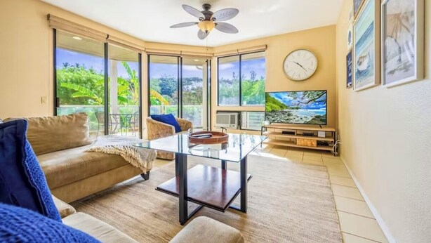A living room with a glass coffee table, a sofa, a television, and a ceiling fan. - Spacious 3BR/2BA Condo in Wailea – Walk to Beach & Shops! (Wailea-Makena)