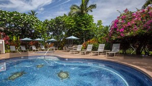 A swimming pool with lounge chairs and umbrellas, surrounded by tropical plants and flowers. - Spacious 3BR/2BA Condo in Wailea – Walk to Beach & Shops! (Wailea-Makena)
