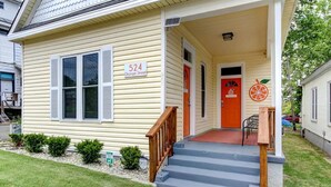 A single-story house with a front porch, a red door, and a number sign indicating the address. - The Tangerine - Walk to Restaurants, Shops, Bars! (Hot Springs)