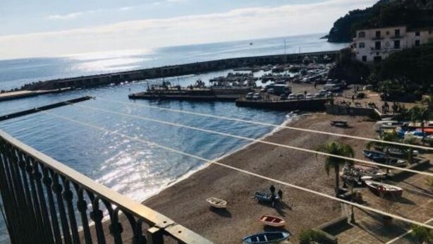 Une vue sur la côte, avec une plage, des bateaux et une jetée.