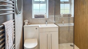 A compact bathroom with a toilet, sink, and shower.
