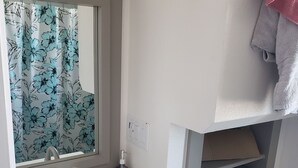 Un baño con lavamanos blanco, un espejo, un inodoro y un perchero para toallas.