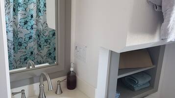 Een douche, handdoeken, zeep, toiletpapier