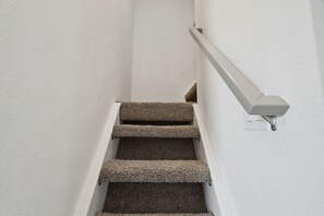 A staircase with carpeted steps and a handrail. - Tiny River Home Beach, Pool, Spa, Boat Launch, Gym, Fishing Pond, Playground (Ehrenberg)