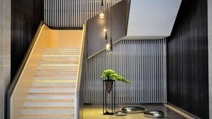 Un escalier moderne avec une rampe en verre, une plante en pot et un design minimaliste.