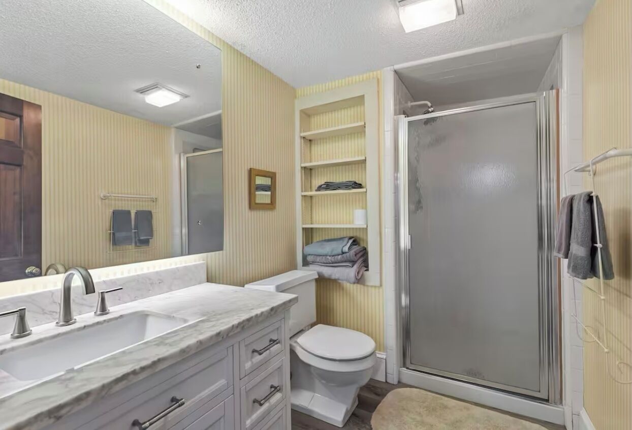 Een badkamer met een wastafel, toilet en douche.