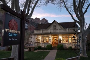 A gallery building with a porch and a signboard.