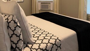 A neatly arranged bedroom with a bed, a window with blinds, and framed pictures on the wall. - Hip Suite-1st Floor - Arts District/Farmers Mkt/Cafes/Breweries-Near Lake George (Glens Falls)