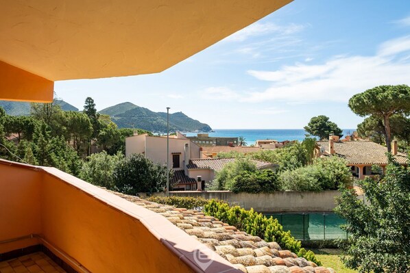 Un balcón con vista a la costa, con edificios y una extensión de agua.