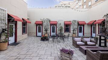 A courtyard with outdoor seating, potted plants, and string lights.