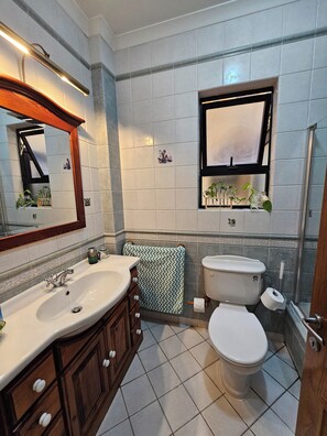A bathroom with a sink, vanity, mirror, toilet, and window. - Country View Apartment (Mellieha)