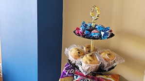 A snack display with mini galettei and chocolate-covered cookies on a three-tiered stand. - Country View Apartment (Mellieha)