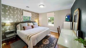A bedroom with a bed, bedside table, lamp, and a large window. - Near Gathering Pl, River Park Trails, Brookside shops (Tulsa)