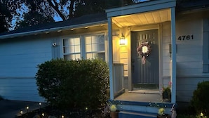 A residential house with a porch, a wreath on the door, and a small American flag. - Near Gathering Pl, River Park Trails, Brookside shops (Tulsa)