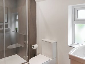 A modern bathroom with a glass shower enclosure, a toilet, and a sink. - 2 bedroom accommodation in Conwy (Conwy)