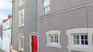 Un edifici amb una porta vermella i diverses finestres.