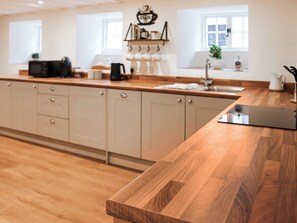 A modern kitchen with wooden countertops, a built-in oven, and a sink. - 2 bedroom accommodation in Conwy (Conwy)