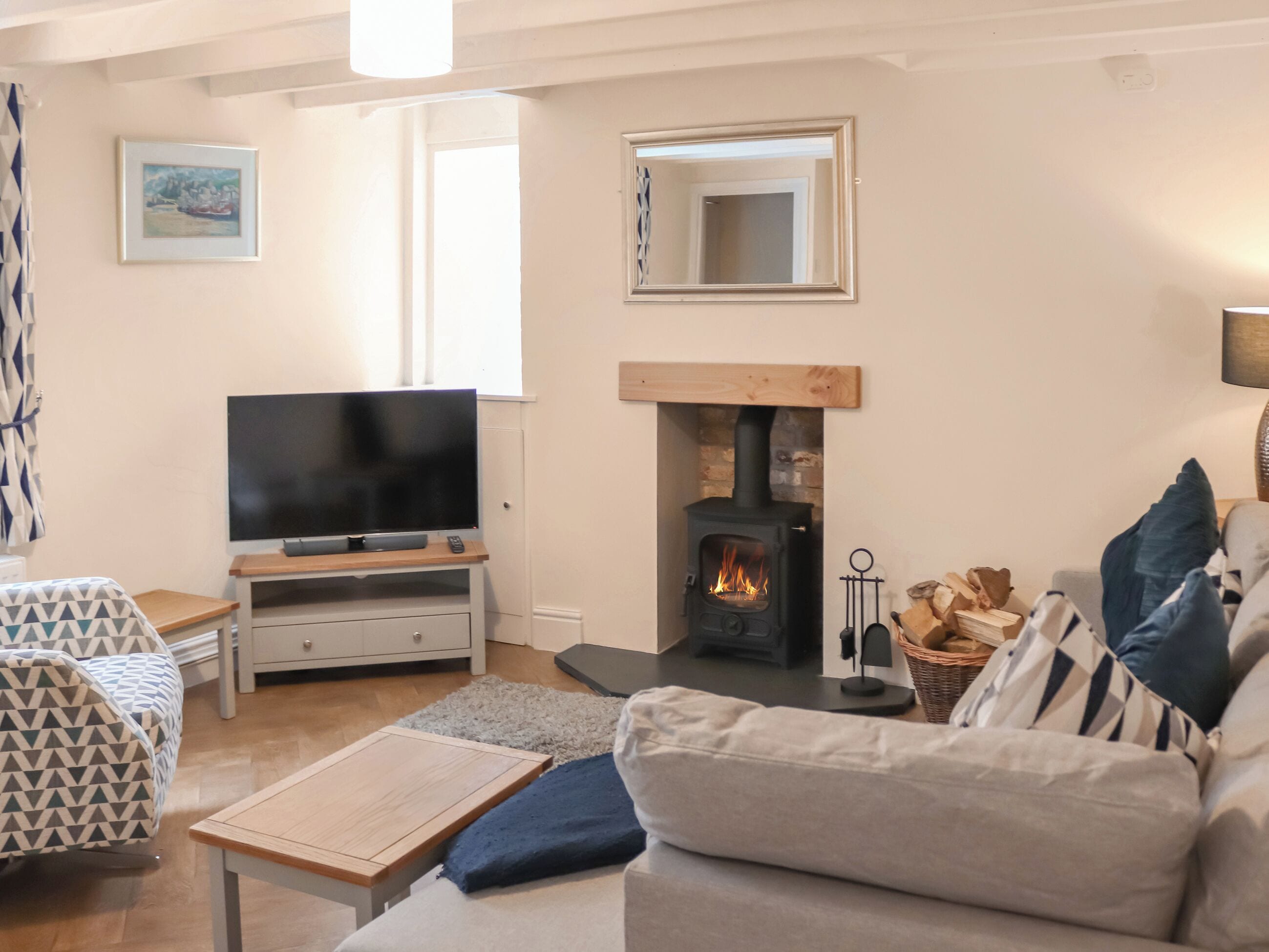 A cozy living room with a television, sofa, and fireplace.