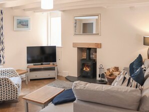 A cozy living room with a television, sofa, and fireplace. - 2 bedroom accommodation in Conwy (Conwy)